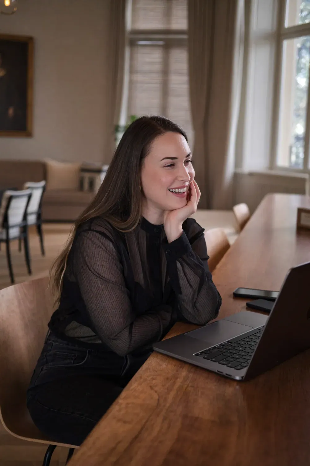 Yasmine Moura, souriante, devant son ordinateur portable